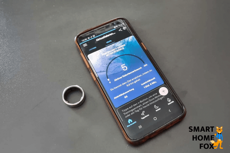 Кольцо Oura Ring лежит рядом с мобильным телефоном на столе